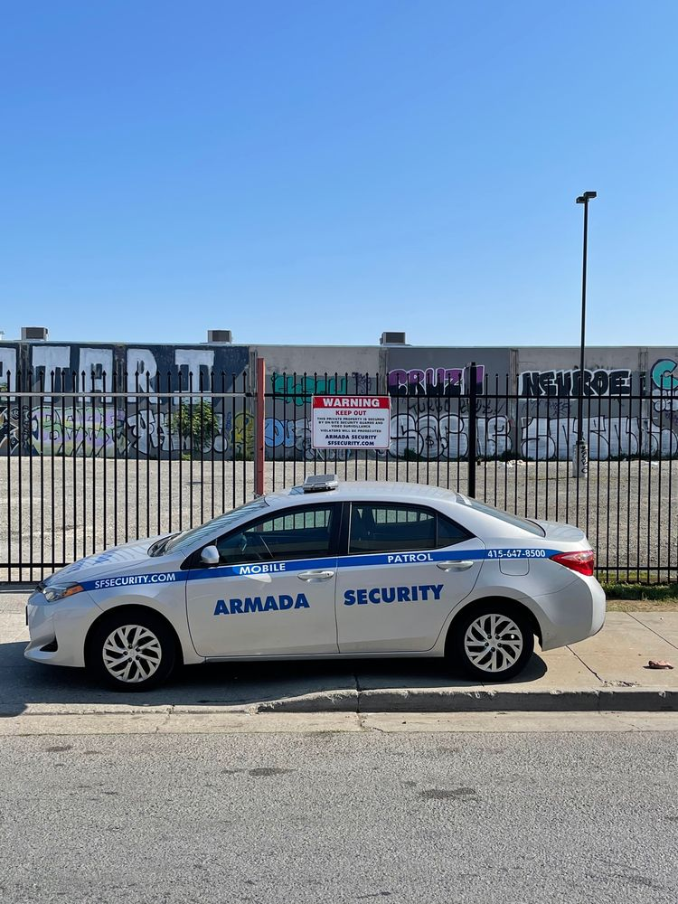 security patrol services in San Francisco - San Francisco Security Services | Best Onsite Security and Mobile Security Patrols in Bay Area | Armada Security Armada Security mobile patrol vehicle parked near a fenced area with a warning sign, highlighting security presence and services.