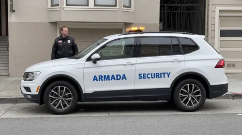 A uniformed patrol officer standing beside the patrol SUV with amber roof lightbar on a San Francisco street, illustrating the topic "hospital security san francisco" — featured image by Armada Security