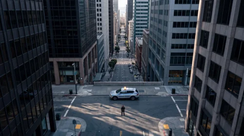 Aerial view of an Armada Security officer and marked patrol SUV responding at an empty downtown San Francisco intersection.